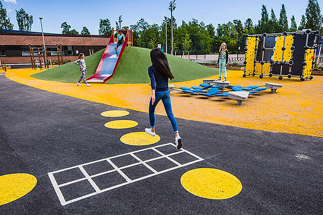 Eloisa, kirkkaan keltaisilla muodoilla koristettu päiväkodin pihamaa.