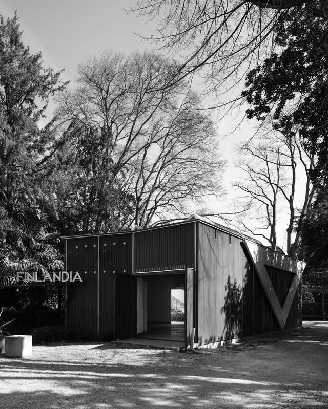 A small wooden pavilion in a park