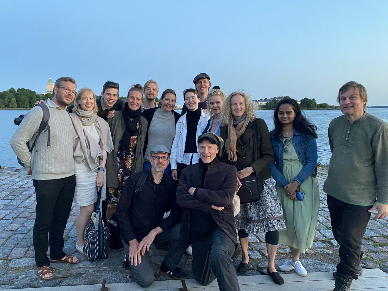 Ryhmä ihmisiä meren äärellä.