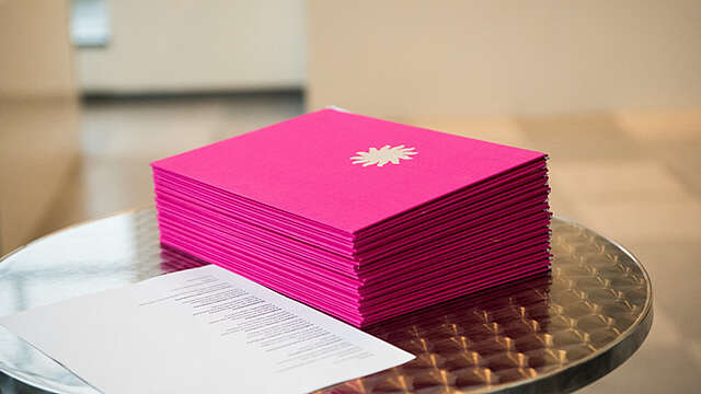 Pile of honorary certificates on a table.