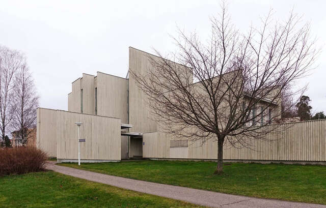 Puinen moderni seurakuntatalo ulkoa nähtynä syksyllä