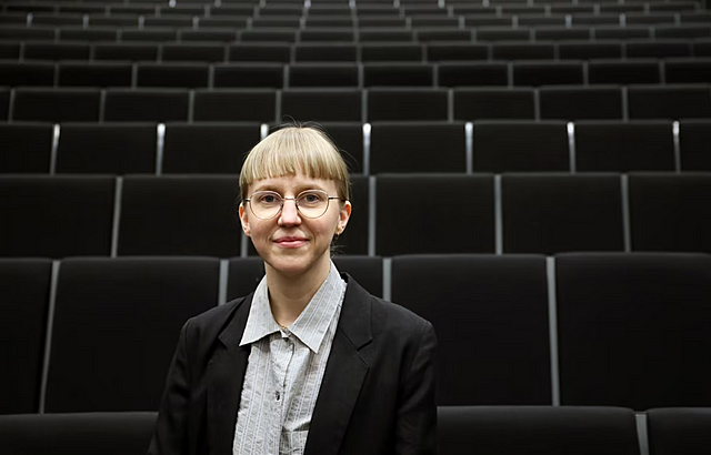 Naispuolinen ihminen istuu tummassa teatterisalissa