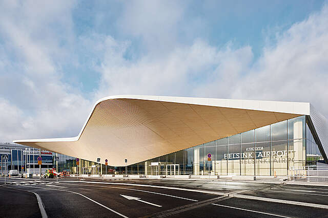 Large airport building with a wooden canopy.