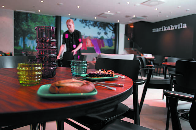Ravintola marikahvila. Yhdellä pöydistä on kakkua ja pullaa