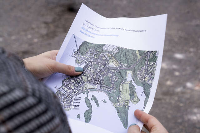 Ihminen pitää käsissään paperia, jossa kartta Helsingistä
