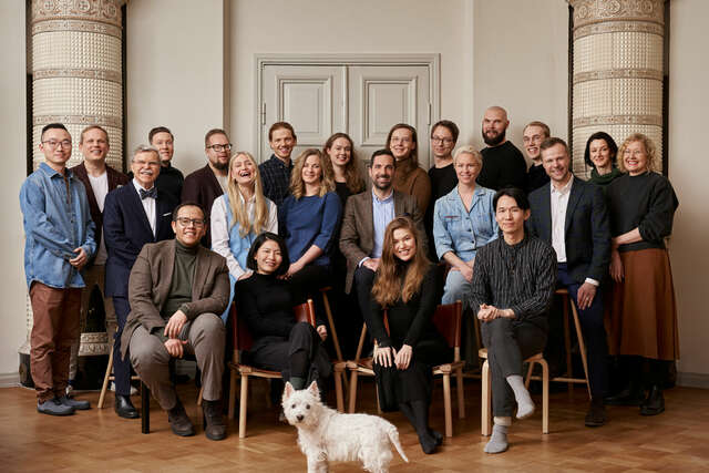 A group of people, a dog in front.