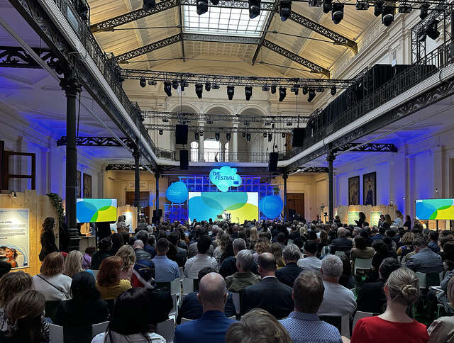 The opening of the event in a covered hall with a large number of people.